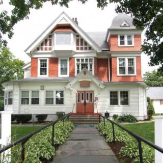 A charming Victorian-style house with a well-maintained garden and pathway.