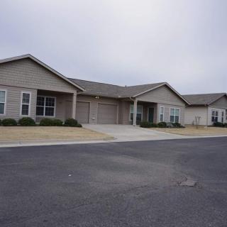 A single-story residential house with a driveway in a suburban area.