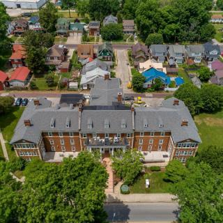 Aerial view of a large building surrounded by a residential neighborhood and greenery.