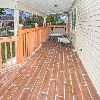 A spacious covered porch with wooden flooring and outdoor seating.