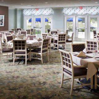 An empty dining room with tables and chairs arranged neatly, showcasing a well-decorated interior.