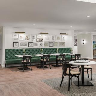 Modern restaurant interior with green booth seating and wall art.