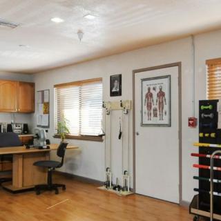 A well-organized medical office with a desk, chair, and various equipment.