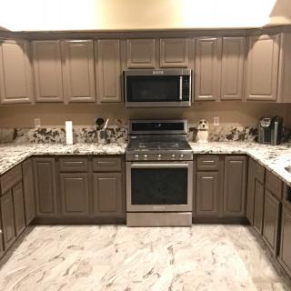 A modern kitchen with brown cabinets and stainless steel appliances.