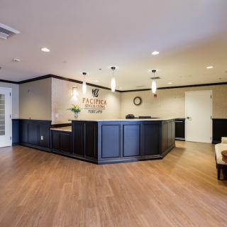 A modern office reception area with a sleek desk and comfortable seating.