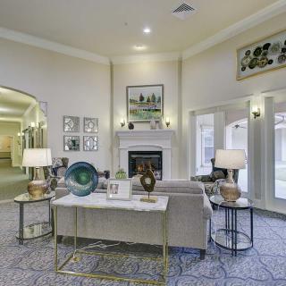 A modern living room featuring elegant decor, a central fireplace, and ample natural light from large windows.