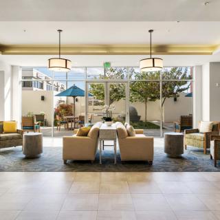A modern hotel lobby with comfortable seating and large windows allowing natural light.