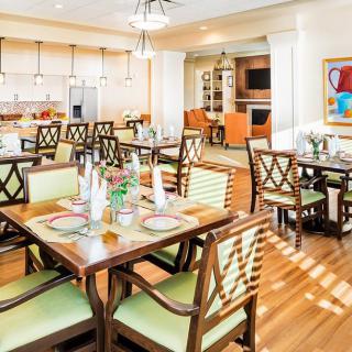 A well-lit dining area with neatly arranged tables and chairs, creating a welcoming atmosphere.