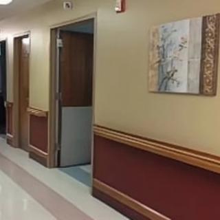 A hallway with doors and a decorative painting on the wall.
