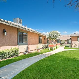 A well-maintained residential area with a green lawn and a pathway.