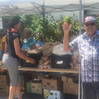 A vibrant community market scene with a vendor happily engaging with customers.