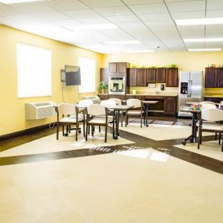 A spacious kitchen and dining area with modern appliances and yellow walls.