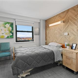 A modern and minimalist bedroom featuring two beds, a wooden accent wall, and a view.