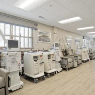 A hospital room filled with dialysis machines arranged in a row.