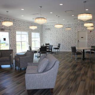 A modern lounge area with comfortable seating, stylish chandeliers, and tables for relaxation.