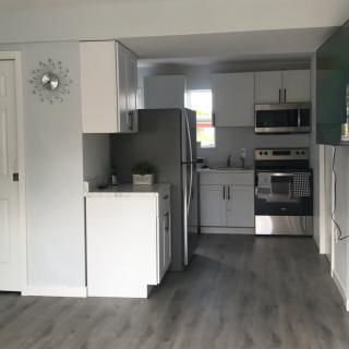 A modern kitchen with white cabinetry and stainless steel appliances.