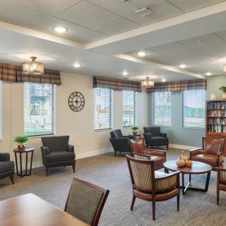 A cozy, well-lit living room with comfortable seating and large windows, perfect for relaxation.