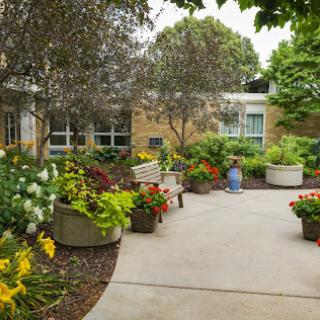 A beautifully landscaped garden featuring vibrant flowers, greenery, and a peaceful pathway.