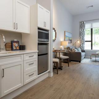 A modern open-concept living space with a kitchen featuring white cabinets and a bright, inviting atmosphere.