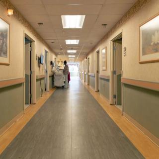 A hospital corridor with staff and medical equipment.