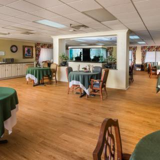 A spacious dining room with neatly arranged tables and chairs, featuring a warm and inviting interior design.