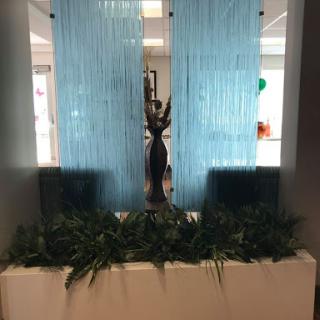 A stylish water feature complemented by blue curtains and decorative plants.