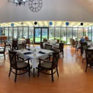 A spacious restaurant dining area with modern decor and abundant natural light.