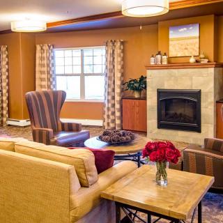 A cozy living room with a sofa, armchairs, and a fireplace.