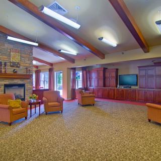 A spacious living room with cozy seating, a fireplace, and a large TV.