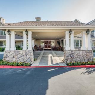 A building entrance with stone columns and a wide covered area.