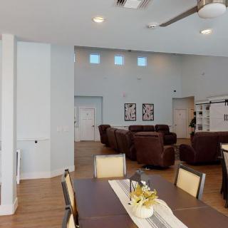 A modern open living and dining area with comfortable seating and a wooden floor.