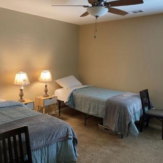 A cozy bedroom with two neatly made single beds and warm lighting.