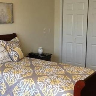A cozy bedroom featuring a patterned bedspread and a nightstand with decor.