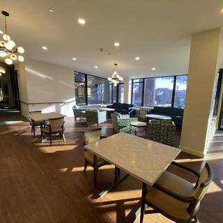 A modern dining area with elegant lighting, comfortable seating, and large windows.