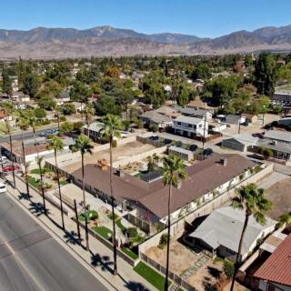 Aerial view of a residential neighborhood with palm trees and mountains in the background.