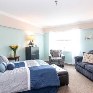 A cozy bedroom with a comfortable bed, sofa, and stylish decor.