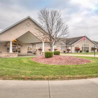 A suburban building with a landscaped lawn and a cloudy sky.