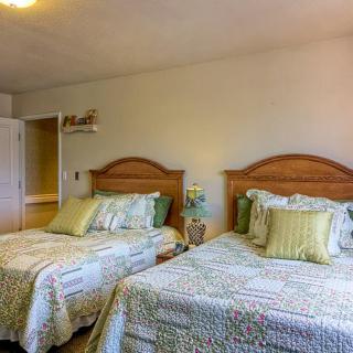 A cozy bedroom with two neatly made beds and decorative pillows.