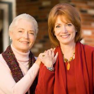 Two women smiling and posing together outdoors.