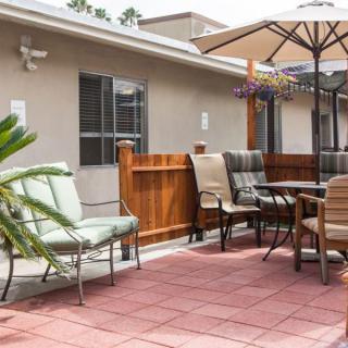 A cozy outdoor patio area with various chairs, a table, and an umbrella.
