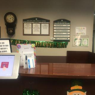 A reception desk with signage, a digital kiosk, and various decorations.