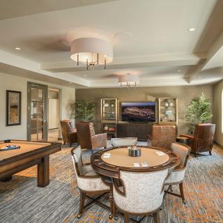 A luxurious lounge area with a pool table, comfortable seating, and a large television.