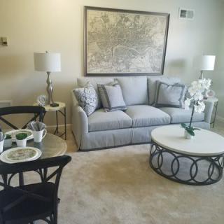 A cozy living room with a comfortable sofa, elegant coffee table, stylish lamps, and decorative wall art.