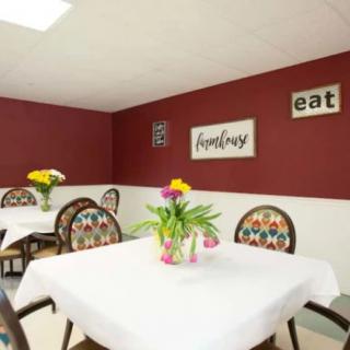 A cozy dining room with decorated tables and wall art.