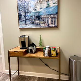 A cozy corner featuring a coffee station with an artistic backdrop.