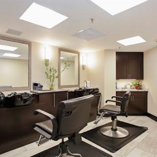 A modern hair salon interior with styling chairs and mirrors.