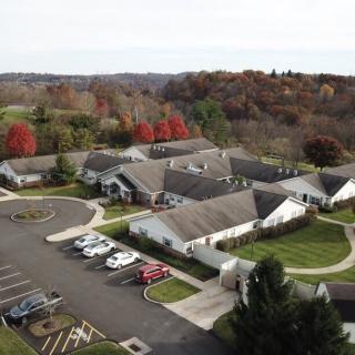 Aerial view of a residential area surrounded by autumn trees.