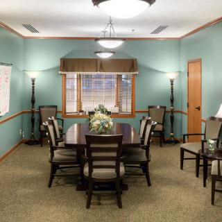 A well-lit conference room with a central meeting table and chairs, featuring elegant interior decor.