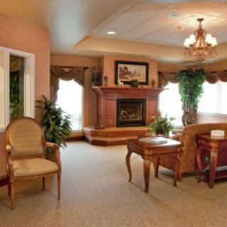 A cozy and elegantly furnished living room with a central fireplace and warm lighting.