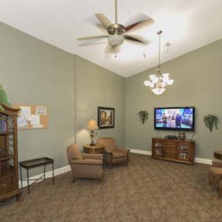 A cozy living room with comfortable seating, a television, and elegant lighting fixtures.